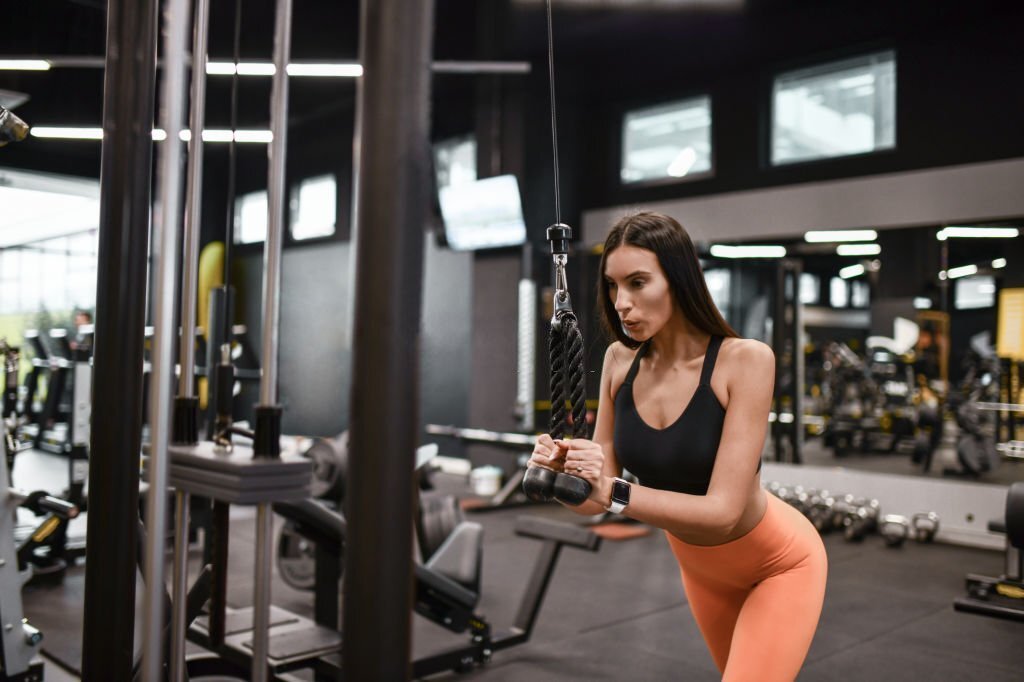 Home cable pushdown exercise in gym by female athlete